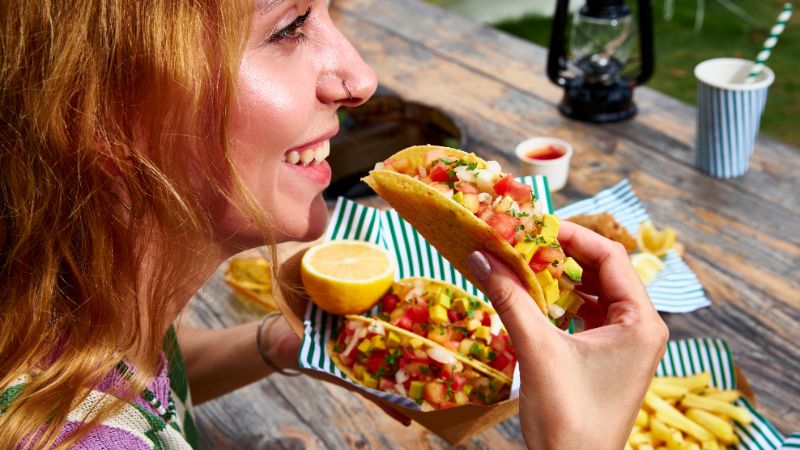 junge frau iss eine tortilla tasche mit geseundem gemüse und ballaststoffen